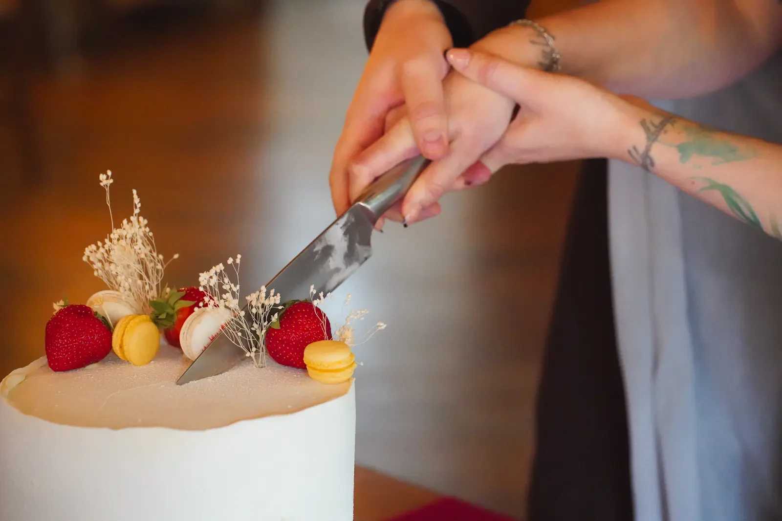 Roke para ob skupnem rezanju okrašene torte.